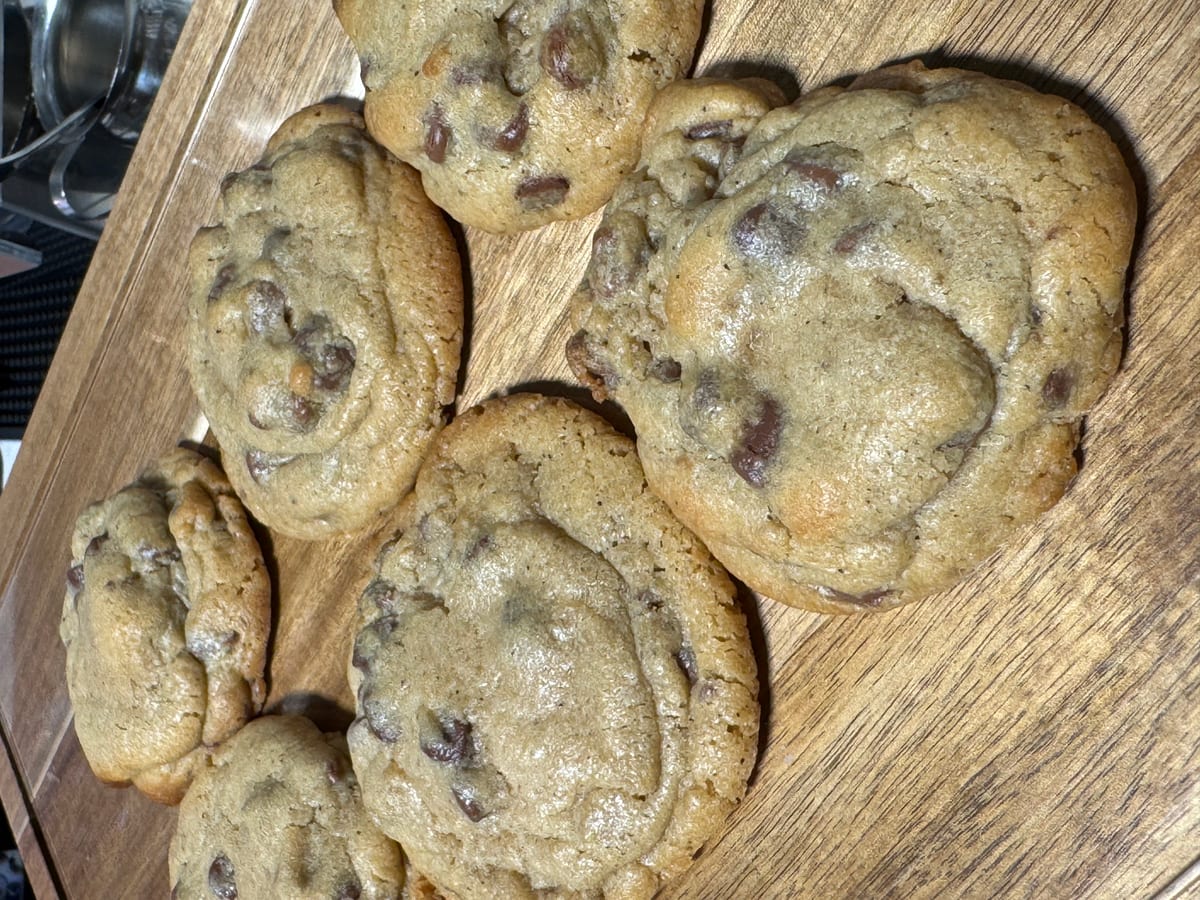 Fresh baked chocolate chip cookies on a wood board